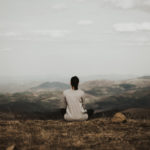 woman sitting on mountaintop