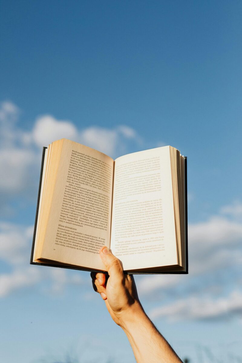 person holding a book outside