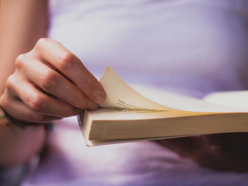 A human flipping a page of a book.