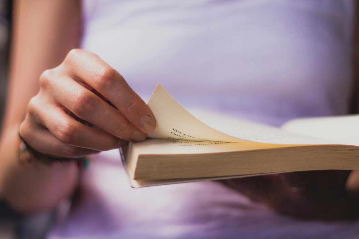 A human flipping a page of a book.